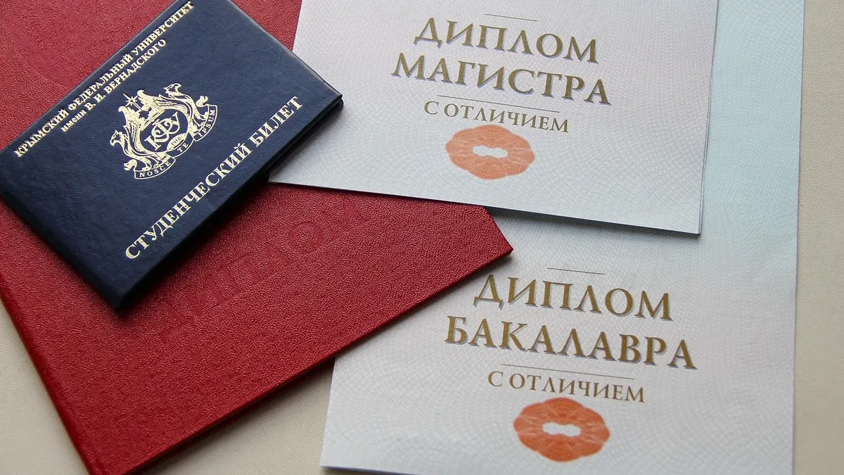 A collection of documents, including a passport, diplomas, and a red folder, arranged on a beige surface.